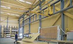 Konsolkran mit Elektrokettenzug und Vakuumheber hebt Holzplatte