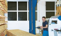 Regalbediengerät mit Elektrokettenzug hebt Holzstapel