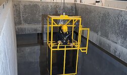 Transportkorb an Elektrokettenzug In der Kabine gelangt die Person zur gewünschten Stelle im Klärbecken.