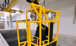 Personentransport mit Kettenzug Die Bedienperson befindet sich im Transportkorb und startet den Absenkvorgang.