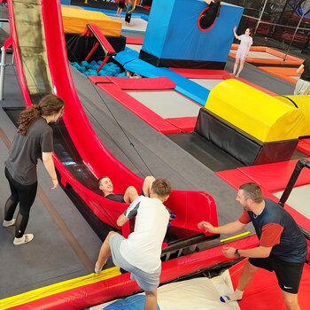 Des apprentis sur le toboggan de la Jump Factory