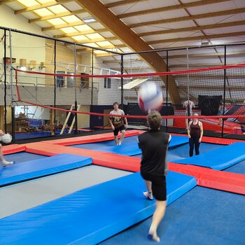 Des apprentis assistent à un match de volley-ball sur trampoline
