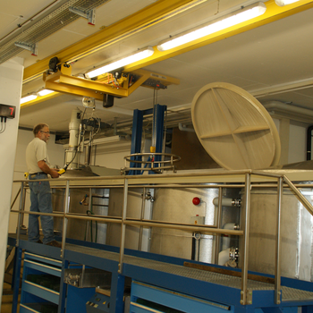 Kransystem hebt Metallbehälter aus Becken