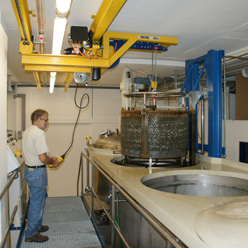 Kransystem hebt Metallbehälter aus Becken