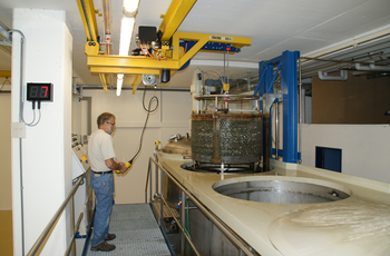 Kransystem hebt Metallbehälter aus Becken