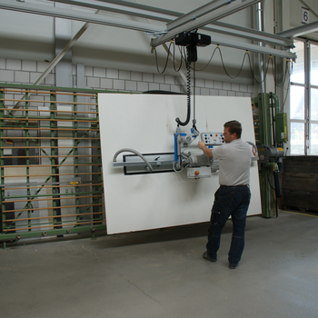 Holzplatte wird mit Vakuum-Handlingsystem vom Hubstapler zur Vertikalsäge transportiert
