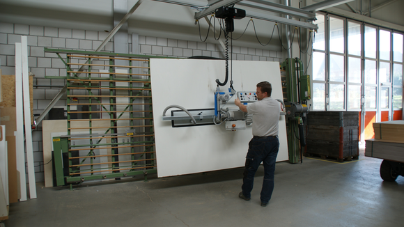 Holzplatte wird mit Vakuum-Handlingsystem vom Hubstapler zur Vertikalsäge transportiert
