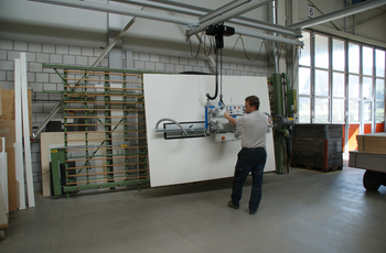 Holzplatte wird mit Vakuum-Handlingsystem vom Hubstapler zur Vertikalsäge transportiert