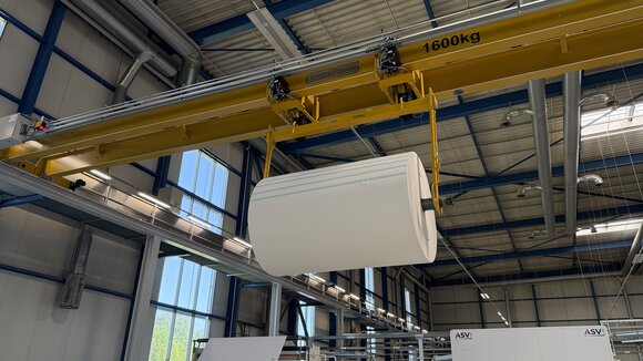 Tandem operation for synchronous lifting The two electric chain hoists of the overhead crane work together to lift the load beam carrying the paper roll.