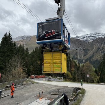 Bei der Talstation nimmt die Gondel einen Container für den Unterlasttransport auf. Die Bedienperson steuert den Vorgang per Funksteuerung.