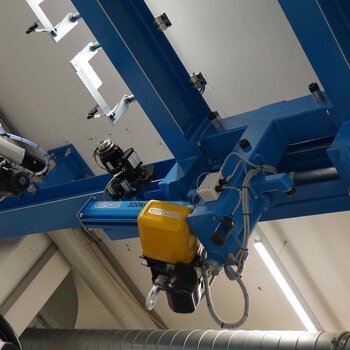 Der Laufkran wird in Längsrichtung verschoben. Hierzu ist der Drehkran eingeschwenkt arretiert und wird zwischen Säule und Handlingroboter bewegt