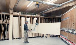 Elektrokettenzug zusammen mit Plattengreifer zum Heben von Holzplatten