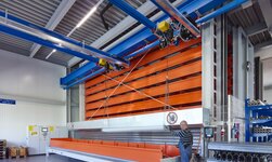 GISKB Kran mit parallelen Kranbrücken hebt lange, sperrige Metallstücke