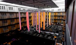 Kettenzug hält Lichtelemente über Personen in Hotellobby