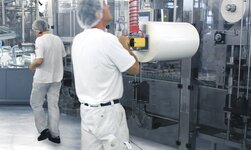 Im Chemiebetrieb wird eine Rolle in die Maschine bewegt mit einem Teleskophandy