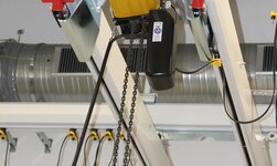 Elektrokettenzug wird zwischen Kranträger platziert für maximale Hubhöhe