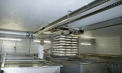 Brückenkran wird in Käserei zum transportieren von käse eingesetzt
